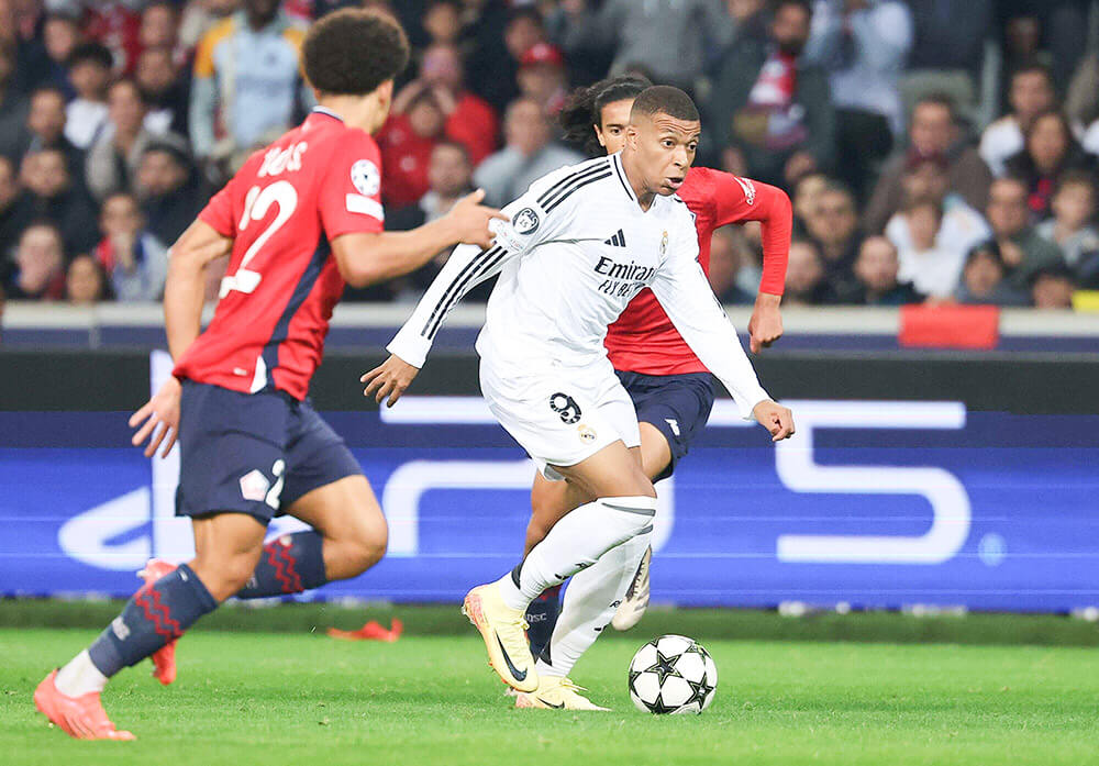 <p>El delantero francés del Real Madrid, Kylian Mbappé (centro) controla el balón durante el partido de fútbol de la UEFA Champions League entre el Lille LOSC y el Real Madrid en el Estadio Pierre Mauroy en Villeneuve-d'Ascq, en el norte de Francia, el 2 de octubre de 2024 - AFP/FRANCK FIFE </p>