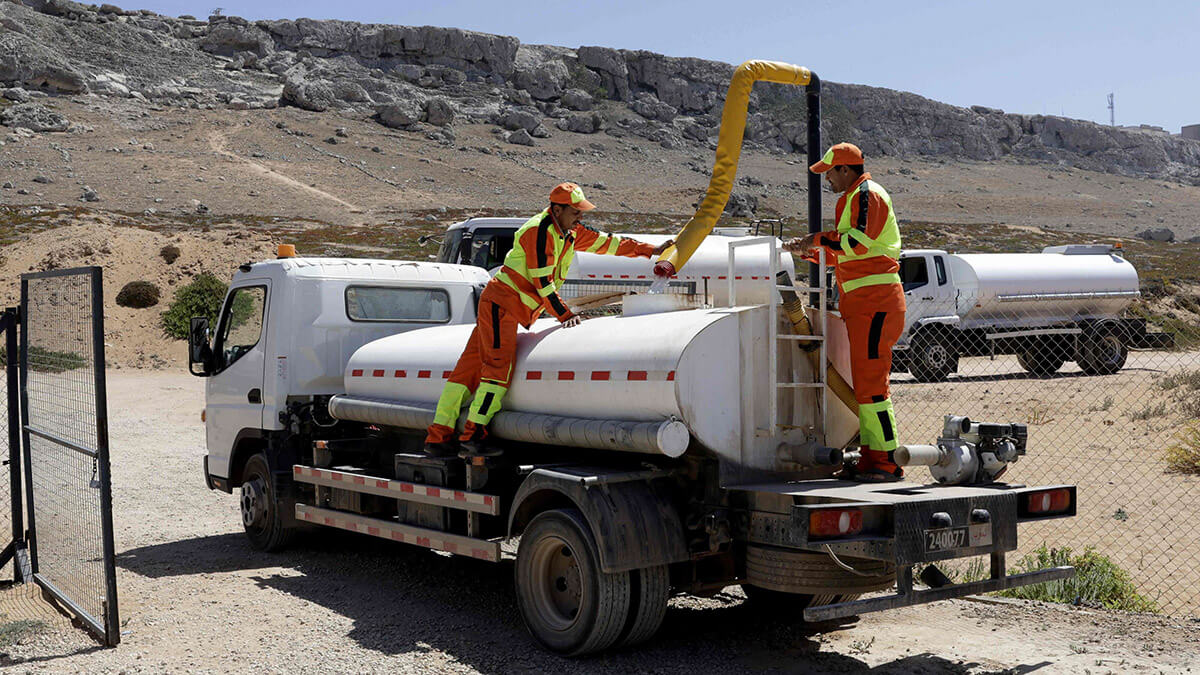 Trabajadores llenan un tanque con agua tratada en una estación desalinizadora móvil también llamada monobloque, en Beddouza, en el oeste de Marruecos - PHOTO/ AFP