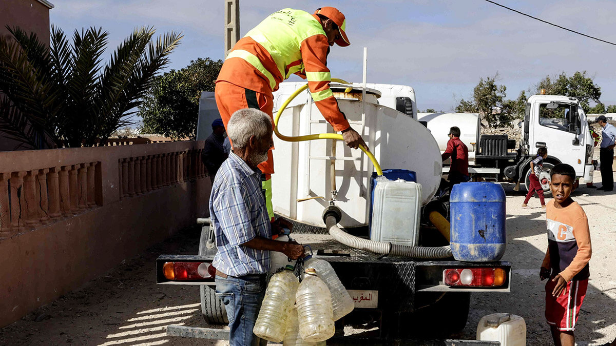 Marroquíes llenan sus contenedores desde un tanque que distribuye agua de mar destilada en el pueblo de Sidi Bouchta, en la región suroccidental de Motoccan El-Beddouza, al norte de Safi - PHOTO/ AFP