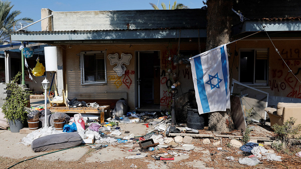 <p>Una bandera israelí cuelga junto a una casa dañada en el kibutz Kfar Aza, en el sur de Israel tras los ataques del 7 de octubre de 2023 - REUTERS/AMIR COHEN </p>