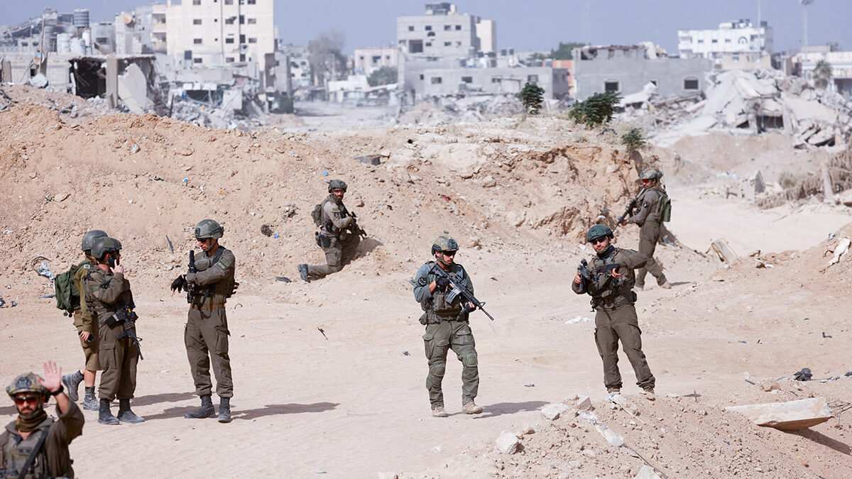 <p>Soldados israelíes hacen guardia mientras se ven edificios dañados al fondo, en medio de la operación terrestre en curso del Ejército israelí contra el grupo islamista palestino Hamás, en la Franja de Gaza, el 13 de septiembre de 2024 - REUTERS/AMIR COHEN </p>
