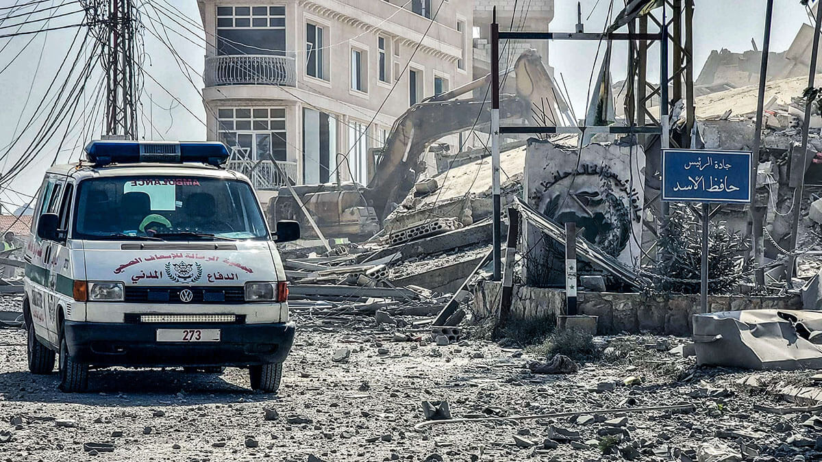 Una ambulancia pasa junto a los escombros de un edificio destruido tras un ataque aéreo israelí en la aldea de Kfar Tibnit, en el sur del Líbano, el 14 de octubre de 2024, en medio de la guerra en curso entre Israel y Hezbolá - AFP/ ADDAS FAKIH