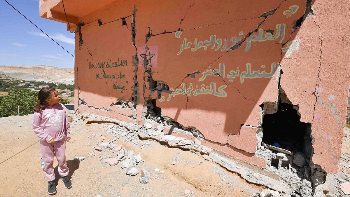 <p> Una niña observa una escuela gravemente dañada en la aldea de Ardouz, en la región marroquí de Amizmiz, afectada por el terremoto, el 14 de septiembre de 2023 - AFP/ FETHI BELAID </p>