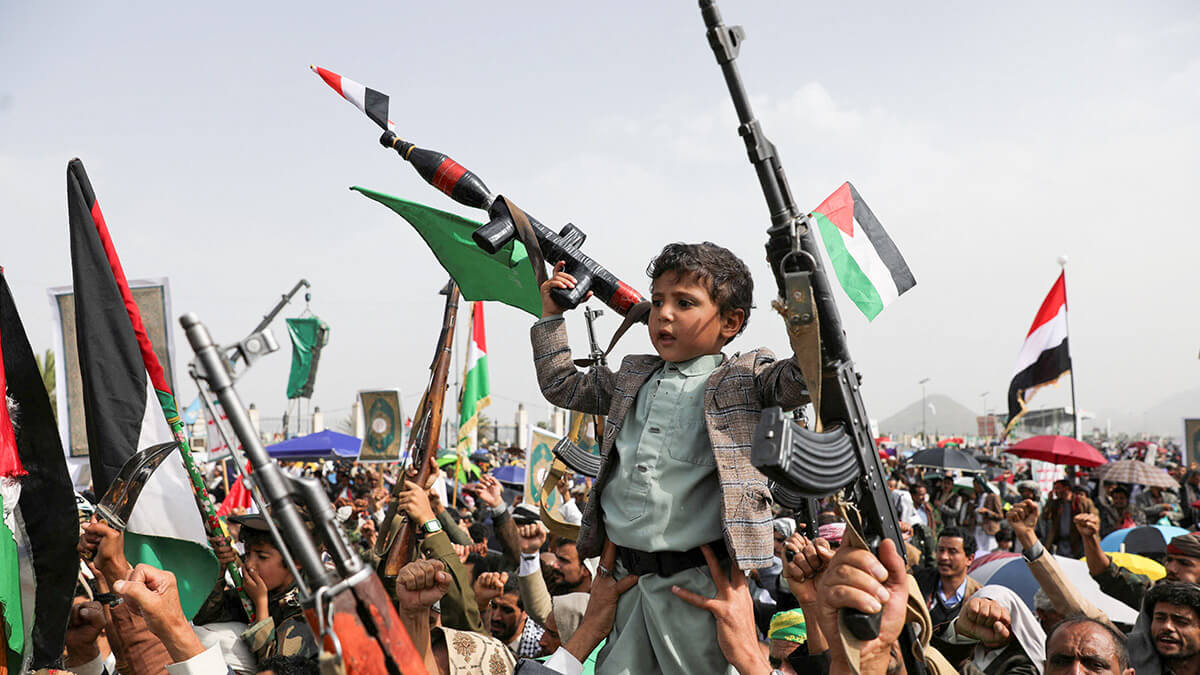 <p>Un niño sostiene una pistola de juguete con una bandera que sobresale de su cañón mientras los manifestantes, principalmente partidarios de los hutíes, sostienen armas y banderas de Palestina y Yemen durante una manifestación para mostrar solidaridad con los palestinos en la Franja de Gaza, en Saná, Yemen, el 30 de agosto de 2024 - REUTERS/KHALED ABDULLAH </p>