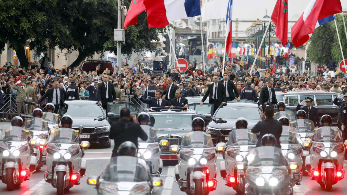 El rey de Marruecos, Mohamed VI, y el presidente de Francia, Emmanuel Macron saludan a la multitud mientras recorren una carretera de la capital, Rabat, el 28 de octubre de 2024 - PHOTO/ LUDOVIC MARIN / POOL / AFP