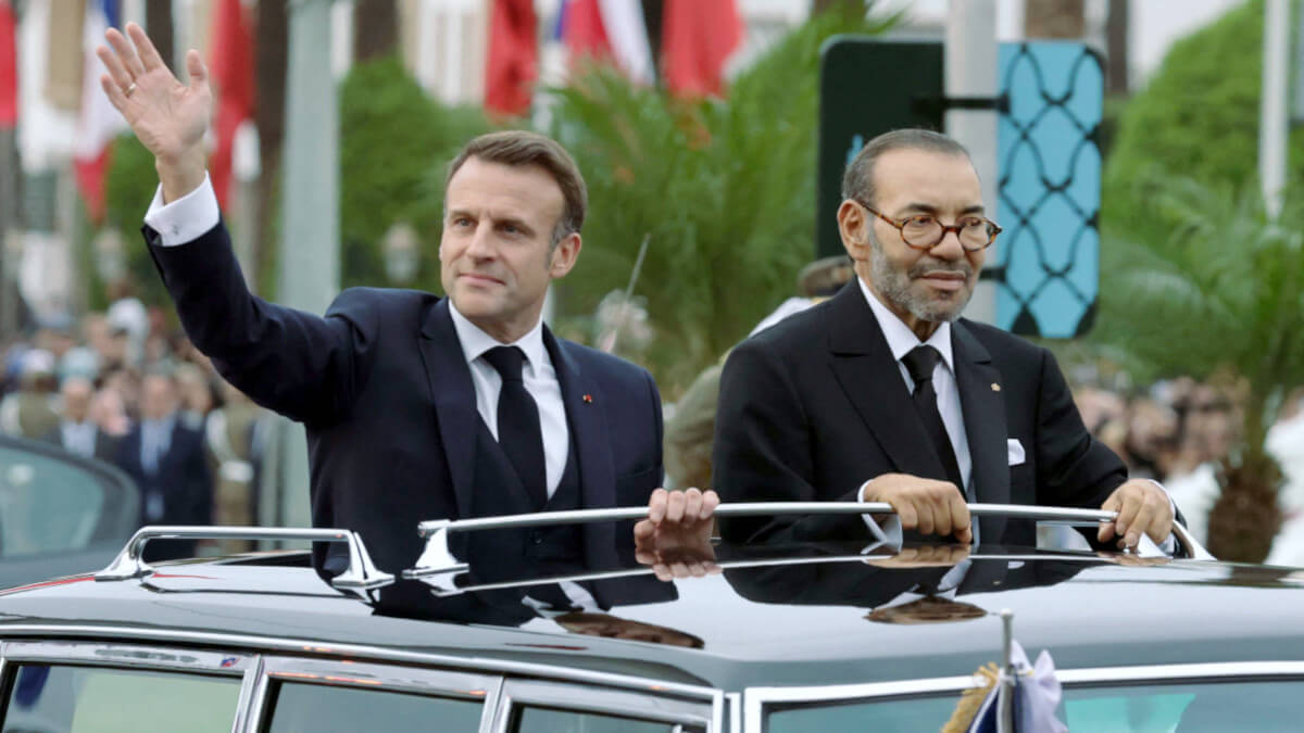 El rey de Marruecos, Mohamed VI, y el presidente de Francia, Emmanuel Macron saludan a la multitud mientras recorren una carretera de la capital, Rabat, el 28 de octubre de 2024 - PHOTO/LUDOVIC MARIN / POOL/AFP