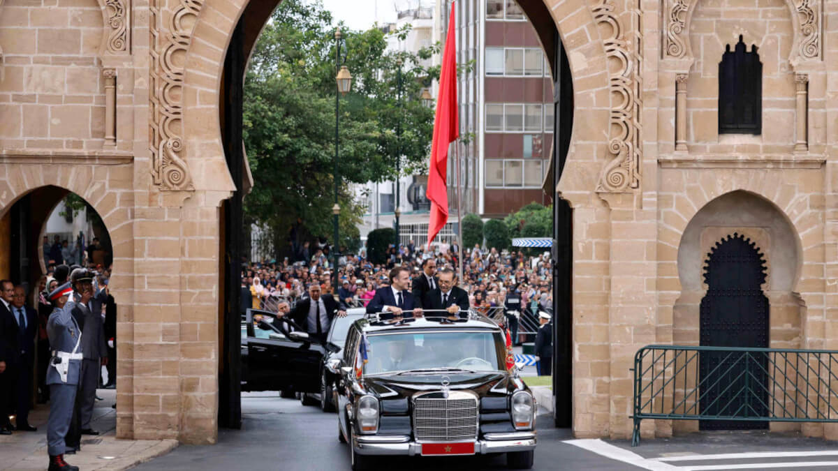 El rey de Marruecos, Mohamed VI, y el presidente de Francia, Emmanuel Macron saludan a la multitud mientras recorren una carretera de la capital, Rabat, el 28 de octubre de 2024 - PHOTO/ LUDOVIC MARIN / POOL / AFP