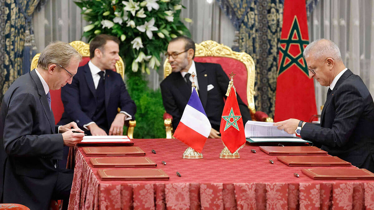 El director general de Alstom, Henri Poupart-Lafarge (izq.), y el presidente de la Oficina Nacional de Ferrocarriles de Marruecos (ONCF), Mohamed Rabie Khlie (der.), firman documentos durante su reunión en el Palacio Real de la capital, Rabat, el 28 de octubre de 2024 - AFP/LUDOVIC MARIN