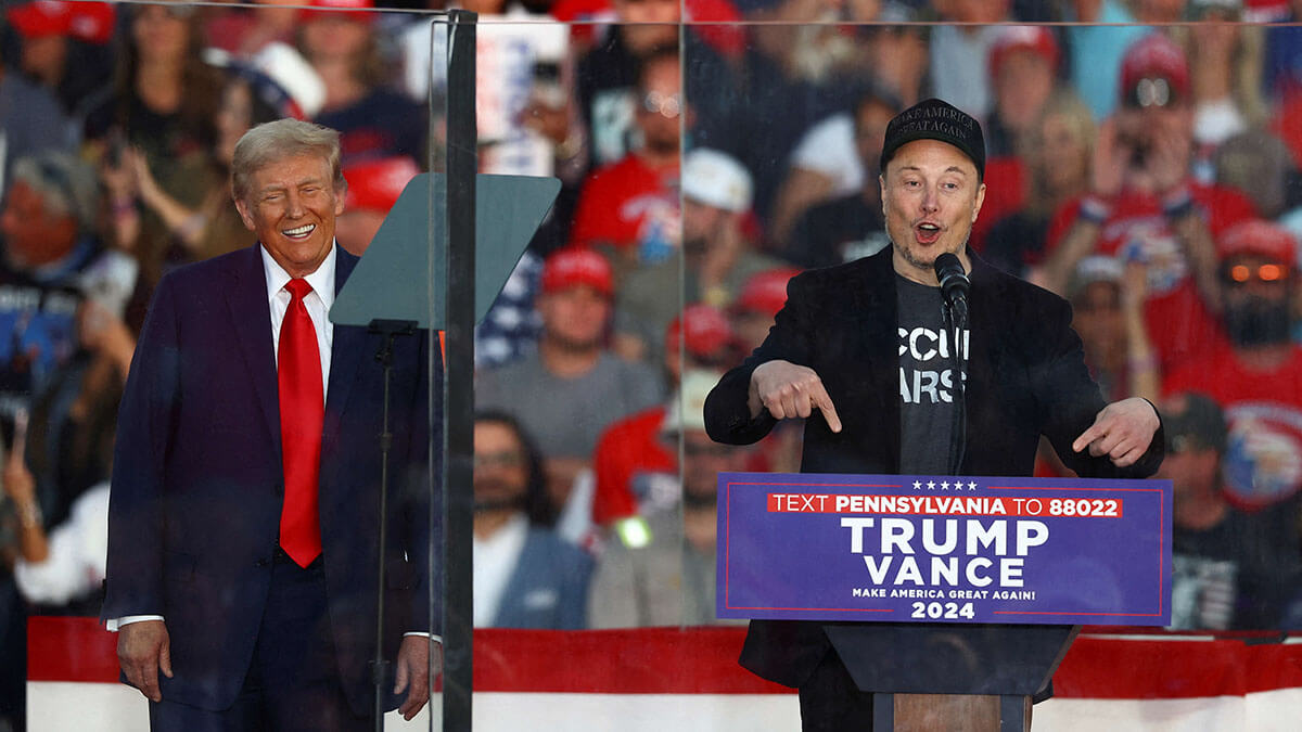 Elon Musk, director ejecutivo de Tesla y propietario de X, habla mientras el candidato presidencial republicano y expresidente estadounidense Donald Trump reacciona durante un mitin en el lugar del intento de asesinato de julio contra Trump, en Butler, Pensilvania, EE. UU., el 5 de octubre de 2024 - REUTERS/CARLOS BERRIA