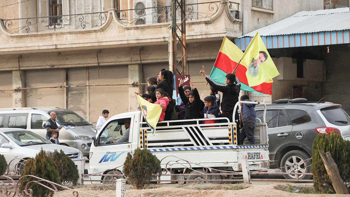 Personas ondeando banderas viajan en la parte trasera de un camión, después de que los rebeldes tomaron la capital y derrocaron al presidente Bashar al-Assad, en Qamishli, Siria, el 8 de diciembre de 2024 - REUTERS/ ORHAN QUEREMAN