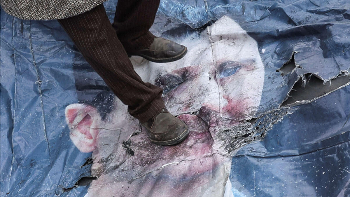 Un hombre pisa una foto de Bashar al-Assad en el centro de Damasco - REUTERS/ AMR ABDALLAH DALSH