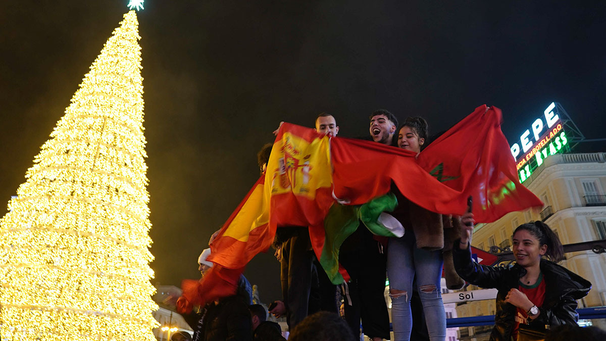 <p>Marroquíes celebran con banderas españolas y marroquíes en la céntrica Puerta del Sol de Madrid, España, el martes 6 de diciembre de 2022 - AP/ ANDREA COMAS</p>