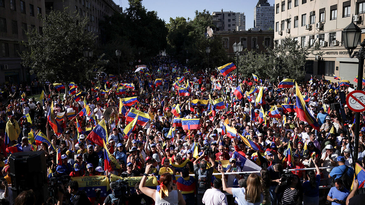 <p>Simpatizantes de la oposición venezolana ondean banderas de Venezuela durante una protesta antes de la investidura del presidente Nicolás Maduro para su tercer mandato el viernes, en Santiago, Chile, el 9 de enero de 2025 - REUTERS/ PABLO SANHUEZA </p>