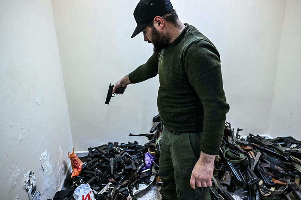 <p>Un miembro de la policía del gobierno de transición de Siria se deshace de una pistola mientras soldados sirios, policías y algunos civiles entregan sus armas y se registran ante las autoridades, en la ciudad portuaria occidental de Latakia, el 16 de diciembre de 2024 - PHOTO/ ARCHIVO</p>
