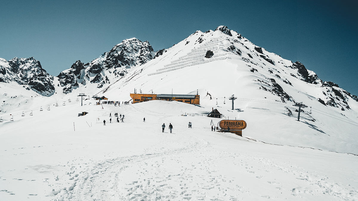Remonte en las montañas de Almaty. Estación de esquí Shymbulak Hotel now-capped Tian Shan en la ciudad de Almaty, Kazajstán - <a data-cke-saved-href="https://depositphotos.com/es/?/" href="https://depositphotos.com/es/?/">Depositphotos</a>