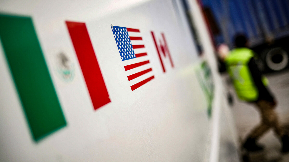 Banderas de México, Estados Unidos y Canadá se muestran en una cabina de seguridad en el puente fronterizo Zaragoza-Ysleta, en Ciudad Juárez, México - REUTERS/ JOSÉ LUIS GONZÁLEZ