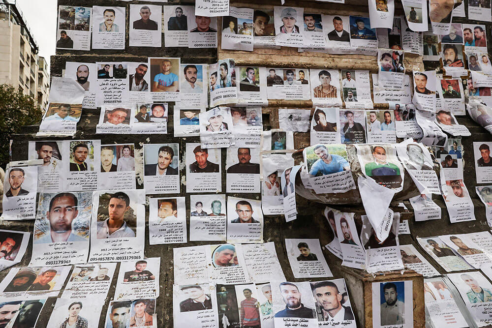 <p>Fotografías de personas desaparecidas, que se cree que eran prisioneros de la prisión de Sednaya, cuelgan en la plaza Marjeh, también conocida como la Plaza de los Mártires, en Damasco - REUTERS/YAMAN SHAAR </p>