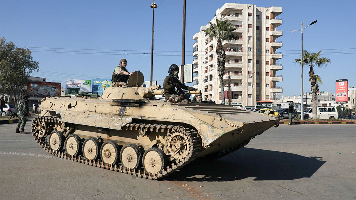 <p>Combatientes de Hayat Tahrir al-Sham (HTS) viajan en un vehículo militar durante lo que dijeron eran controles de seguridad para encontrar restos de la fuerza del derrocado presidente sirio Bashar al-Assad, en el barrio de Wadi al-Dahab en Homs, Siria - REUTERS/ KHALIL ASHAWI</p>