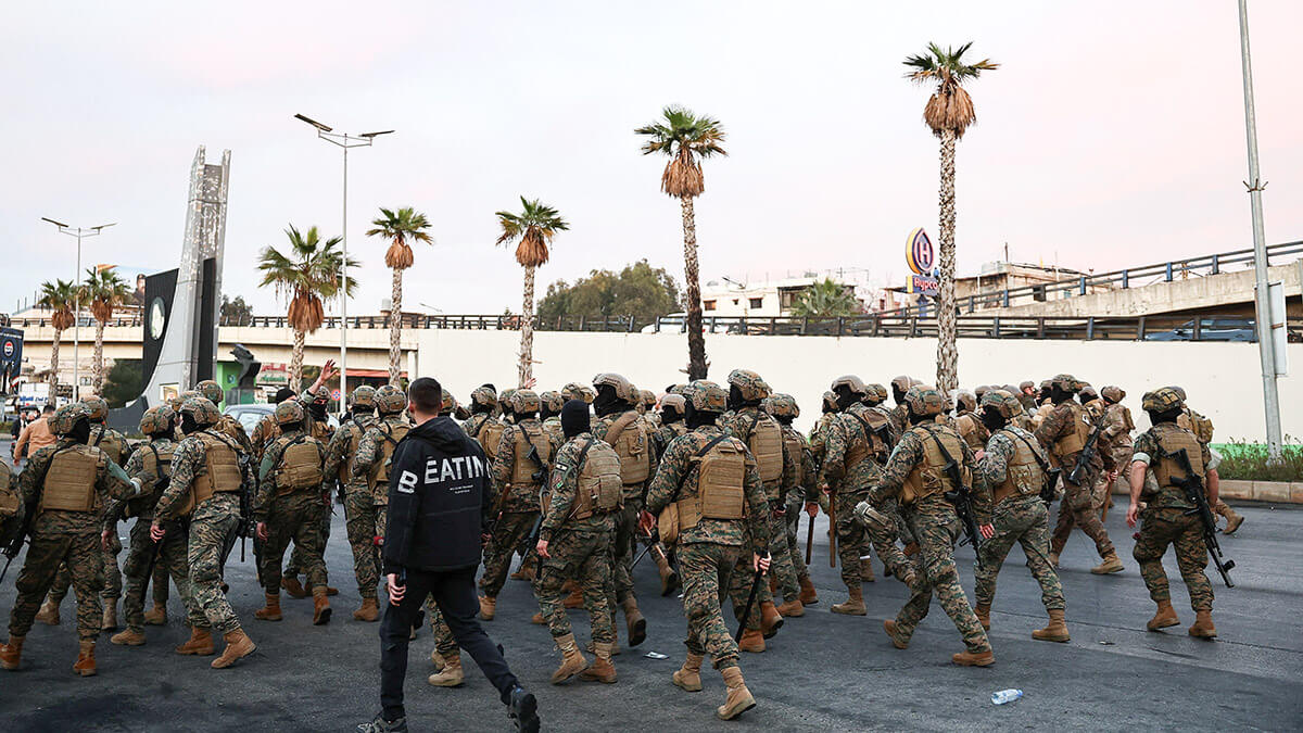 Miembros del ejército libanés caminan mientras partidarios de Hezbolá asisten a una protesta organizada por ellos contra lo que dijeron que era una violación de la soberanía nacional, cerca del aeropuerto internacional de Beirut, Líbano, el 15 de febrero de 2025 - REUTERS/EMILIE MADI