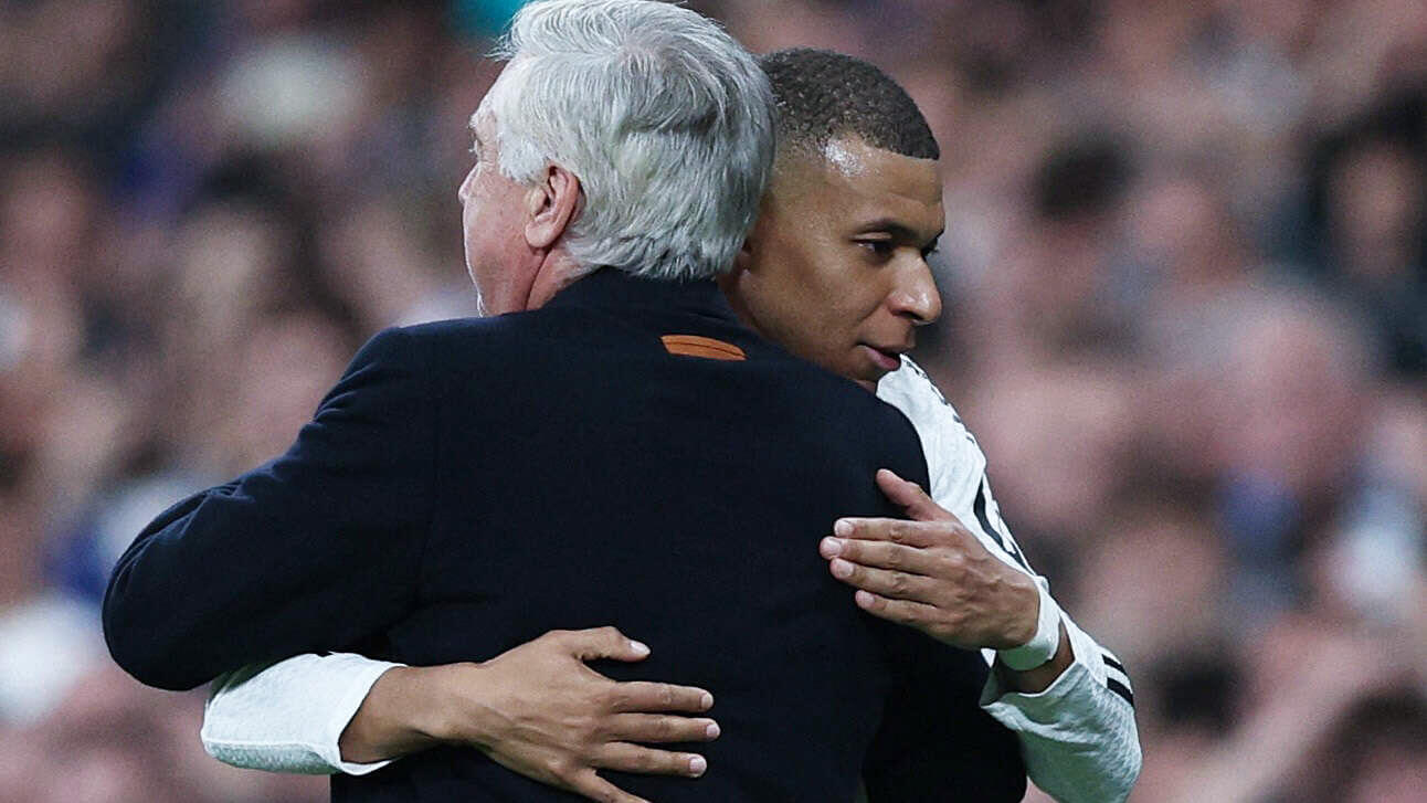 El delantero francés del Real Madrid Kylian Mbappé abraza al entrenador italiano del Real Madrid, Carlo Ancelotti - REUTERS/ VIOLETA SANTOS MOURA
