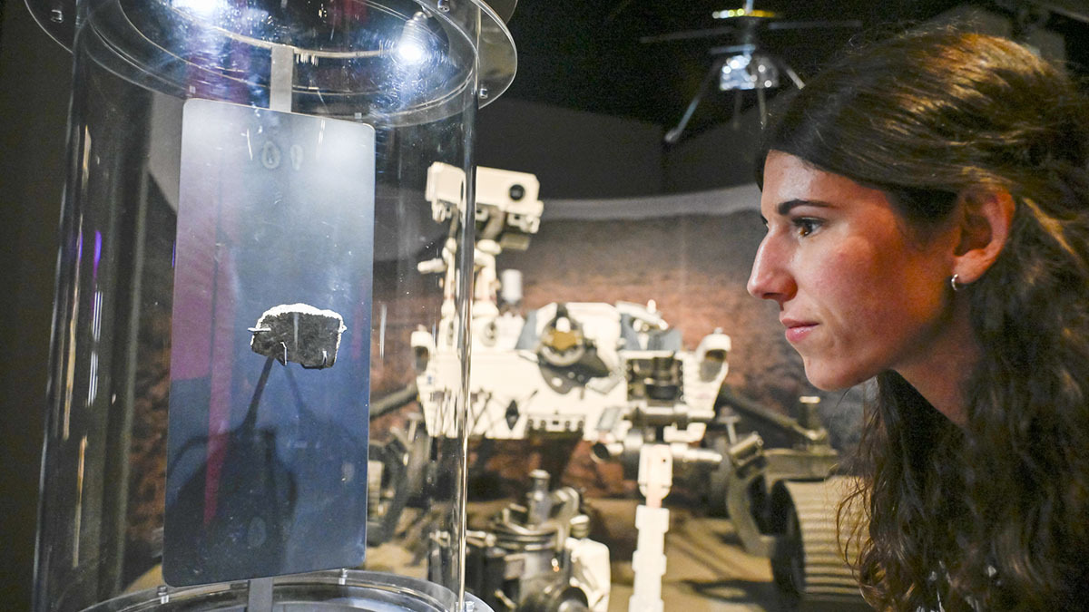 <p>Una visitante observa de cerca la shergottita marciana - PHOTO/ Fundación "la Caixa" </p>
