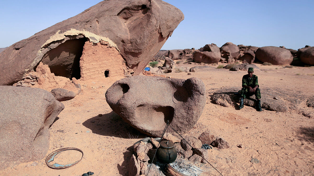 Un combatiente del Polisario se sienta en una roca en una base avanzada en las afueras de Tifariti, Sahara Occidental - REUTERS/ ZOHRA BENSEMRA