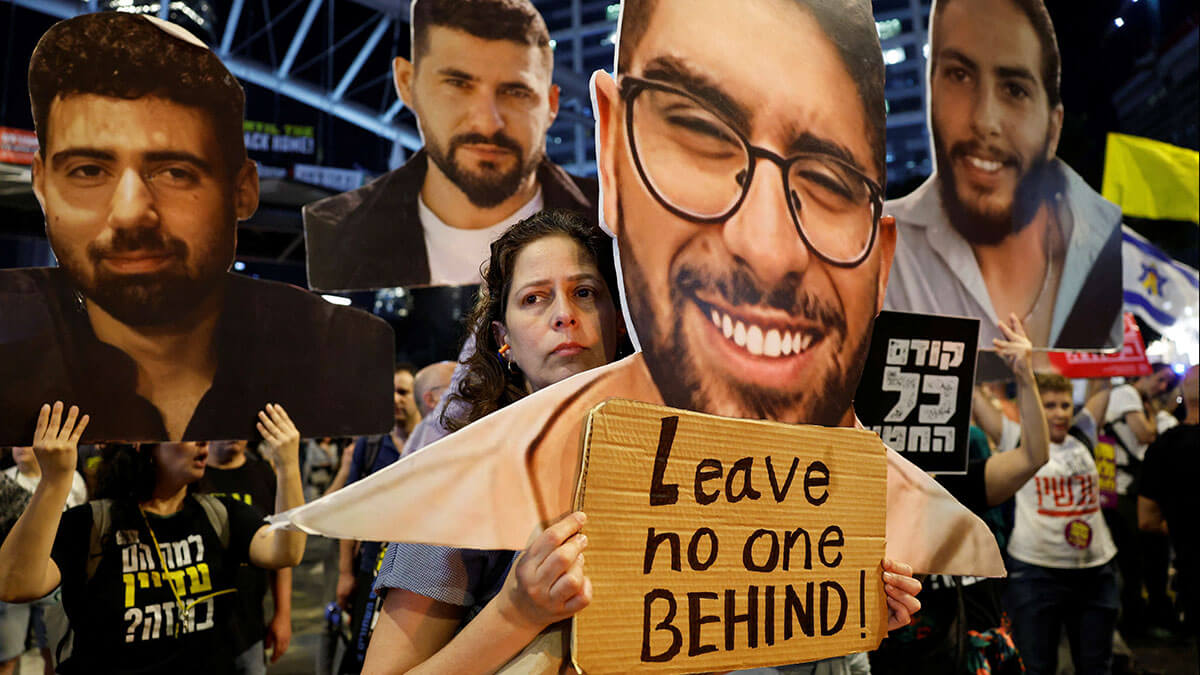 Familiares y simpatizantes de los rehenes israelíes secuestrados durante el mortal ataque del 7 de octubre de 2023 contra Israel por parte de Hamás sostienen imágenes de rehenes durante una protesta para exigir la liberación de todos los rehenes, en Tel Aviv, Israel, el 13 de marzo de 2025 - REUTERS/ AMIR COHEN
