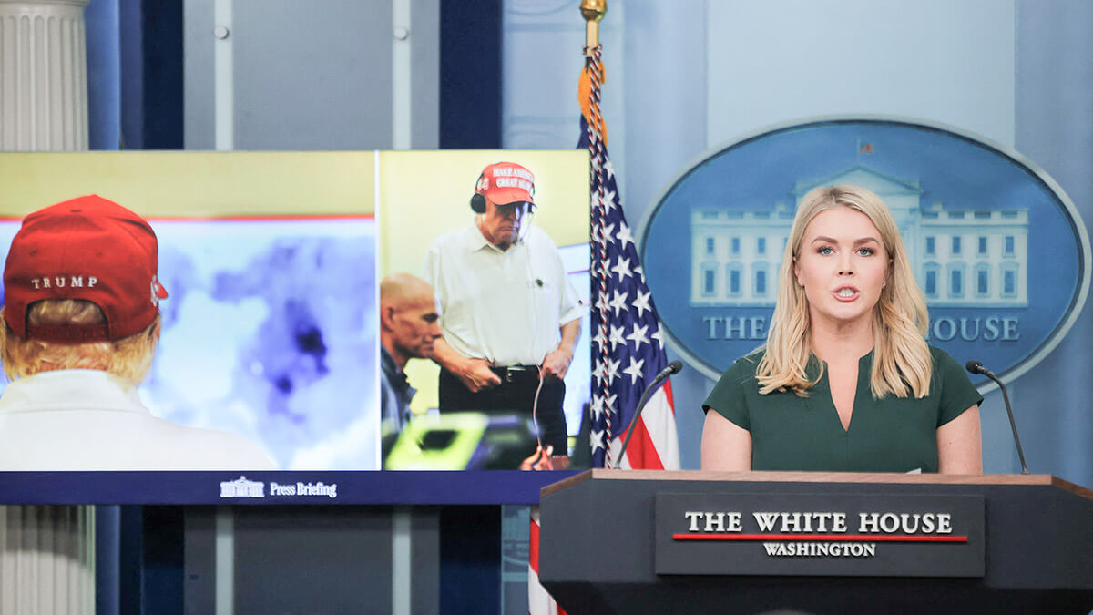 La secretaria de prensa de la Casa Blanca, Karoline Leavitt, mientras se muestran imágenes del presidente estadounidense Donald Trump recibiendo información sobre los ataques militares lanzados contra los hutíes de Yemen en la sala de prensa de la Casa Blanca, en Washington, DC, EE.UU., el 17 de marzo de 2025 - REUTERS/ CARLOS BARRIA