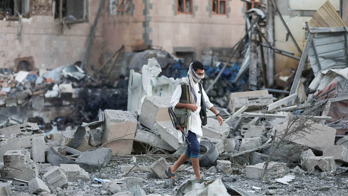 Un hombre armado camina en el lugar de los ataques estadounidenses en Saná, Yemen, el 20 de marzo de 2025 - REUTERS/ KHALED ABDULLAH