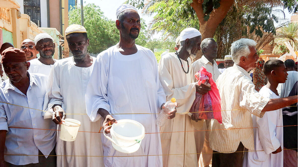 Hombres sudaneses esperan para recibir raciones de comida de Takaya, el restaurante benéfico y cocina comunitaria que ayuda a los sudaneses necesitados en las zonas de Omdurman recientemente controladas por el ejército - REUTERS/ EL TAYEB SIDDIG