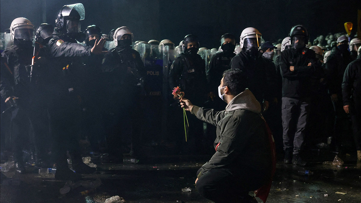 Una persona sostiene una flor ante los agentes de policía durante una protesta - REUTERS/ ALEXANDROS AVRAMIDIS