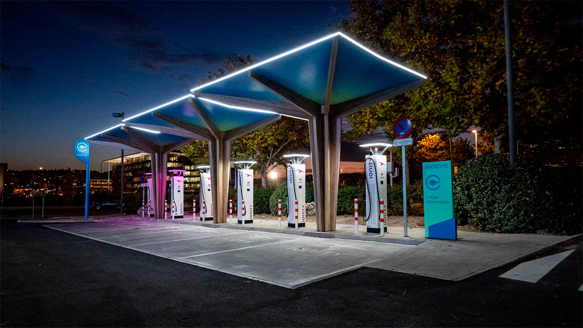 <p>Puestos de carga de vehículos eléctricos de Moeve iluminados durante la noche - PHOTO/ MOEVE</p>