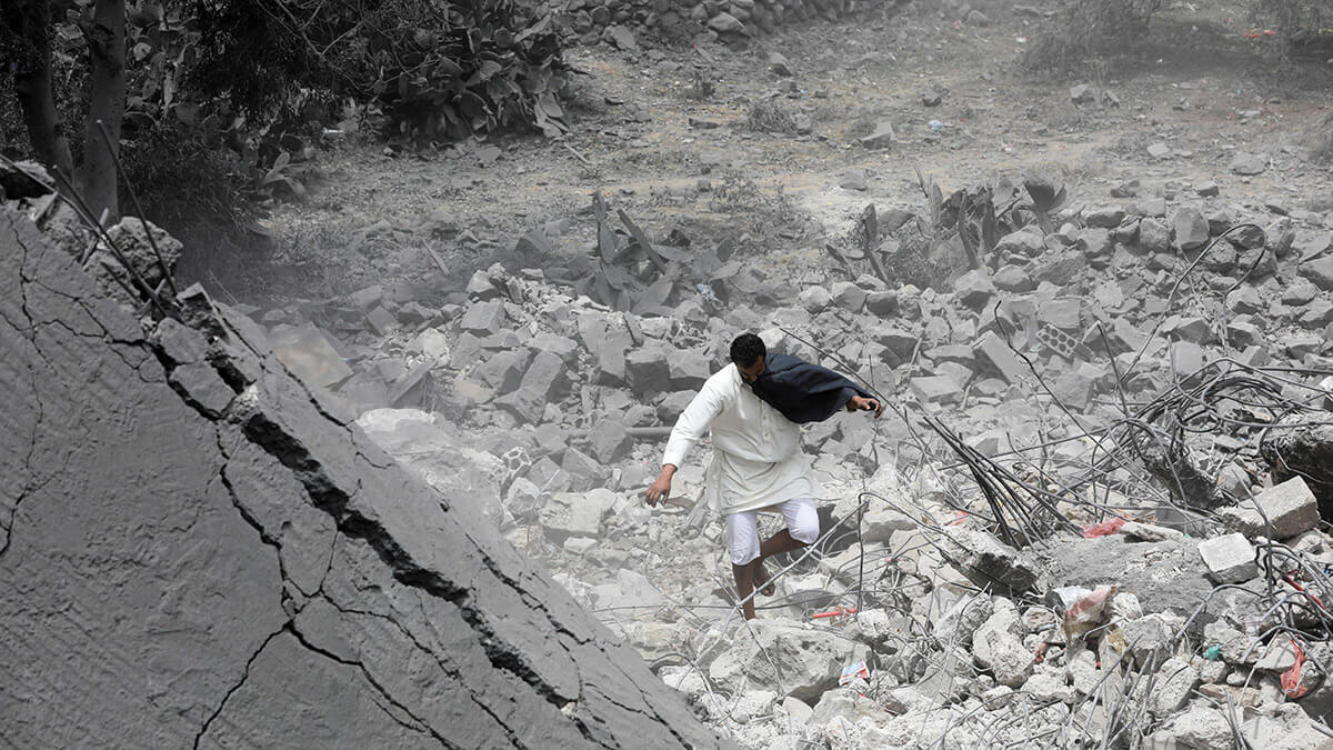 Un hombre camina sobre escombros en el lugar de un ataque estadounidense en Saná, Yemen, el 24 de marzo de 2025 - REUTERS/ KHALED ABDULLAH