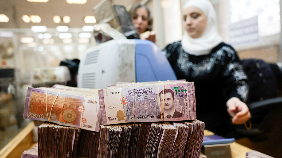 Fajos de billetes sirios se apilan mientras un empleado cuenta el dinero en el banco central sirio, tras el derrocamiento de Bashar al-Assad, en Damasco, Siria - REUTERS/ AMMAR AWAD