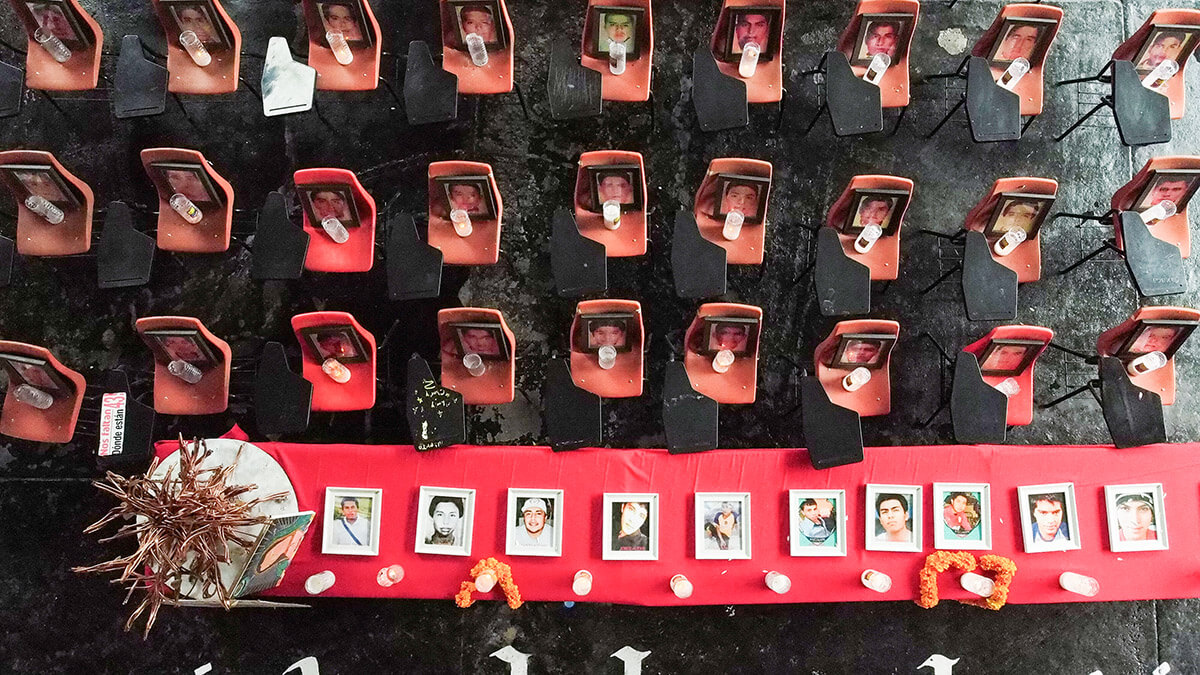 Escritorios adornados con velas votivas y fotos de los estudiantes asesinados y los 43 estudiantes desaparecidos de la escuela normal rural de Ayotzinapa, antes del décimo aniversario de su desaparición, en Tixtla, México, el 22 de septiembre de 2024 - REUTERS/ QUETZALLI NICTE-HA