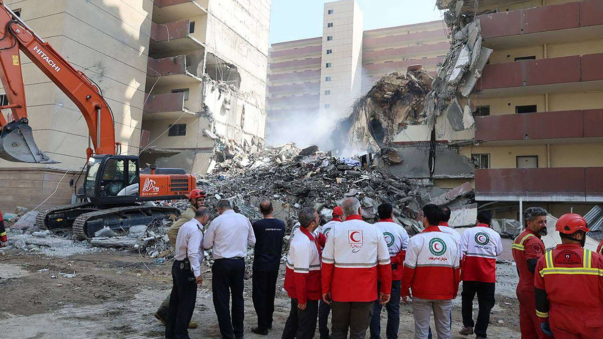 Esta fotografía, publicada por la Media Luna Roja Iraní el 14 de junio de 2025, muestra a voluntarios de la Media Luna Roja Iraní reunidos frente a un edificio destruido por un ataque israelí en Teherán - PHOTO/ Media Luna Roja Iraní