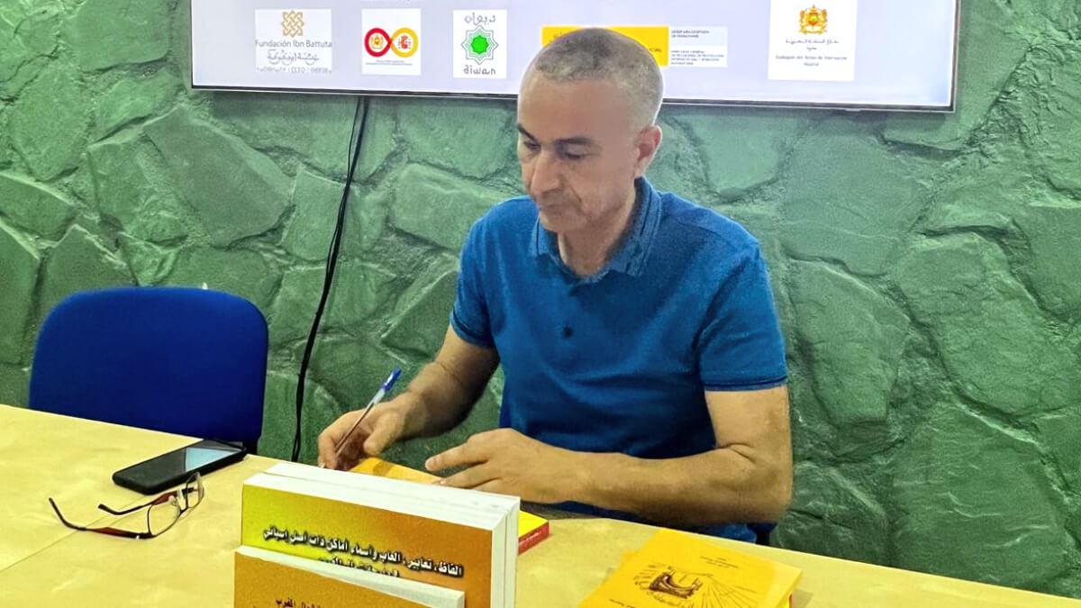 Mohamed Nouri, escritor del libro "Vocablos españoles en la lengua del norte de Marruecos", durante la presentación de éste en la sede de la Fundación Ibn Battuta, firmando alguno de sus ejemplares - PHOTO/ATALAYAR