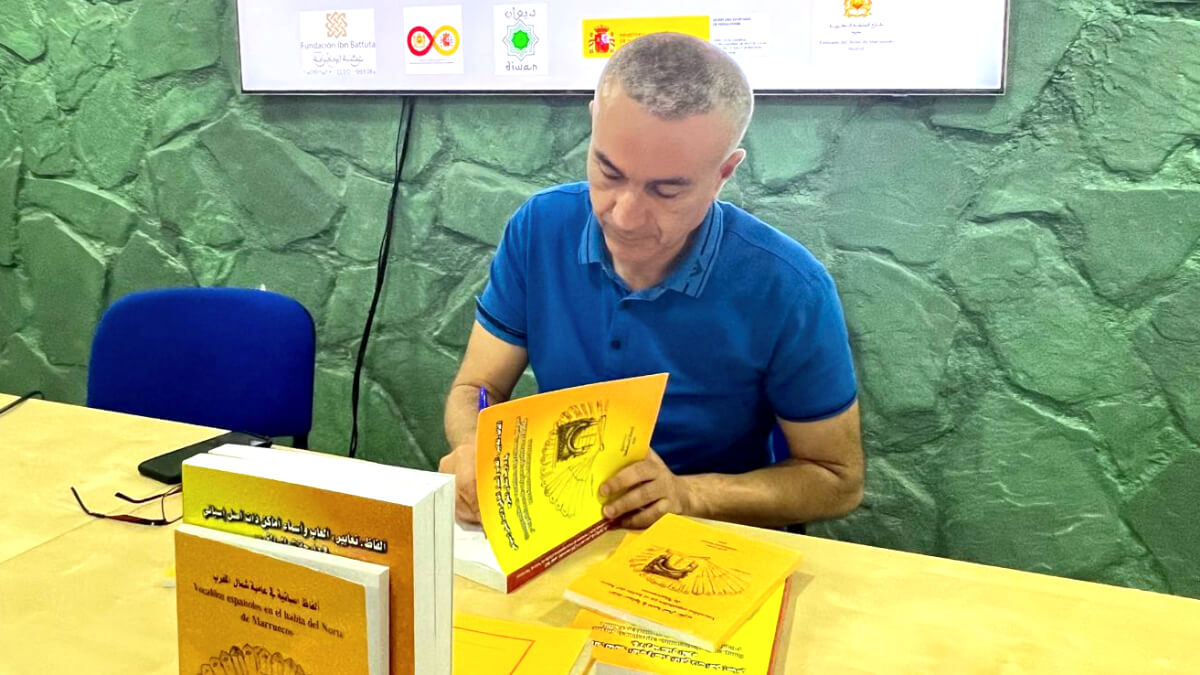 Mohamed Nouri, escritor del libro "Vocablos españoles en la lengua del norte de Marruecos", durante la presentación de éste en la sede de la Fundación Ibn Battuta, firmando alguno de sus ejemplares - PHOTO/ATALAYAR
