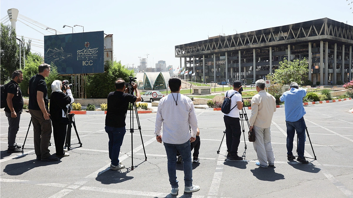 <p>Periodistas son vistos sonriendo tras el ataque israelí contra el edificio de la emisora de televisión estatal de Irán, que fue el objetivo, en Teherán, Irán, el 19 de junio de 2025 - WANA/MAJID ASGARIPOUR vía REUTERS</p>