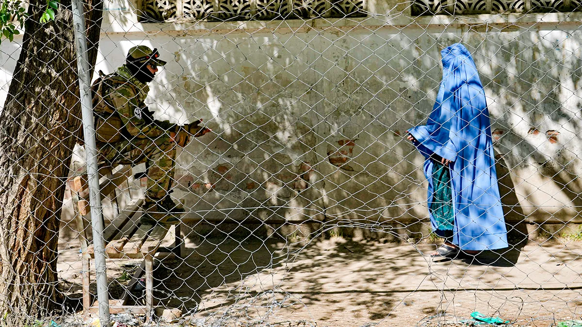 <p>Un combatiente talibán hace guardia mientras una mujer entra en la oficina de pasaportes del gobierno en Kabul, Afganistán, el miércoles 27 de abril de 2022. El liderazgo talibán de Afganistán ha ordenado a todas las mujeres afganas usar el burka en público - AP/ EBRAHIM NOROOZI</p>
