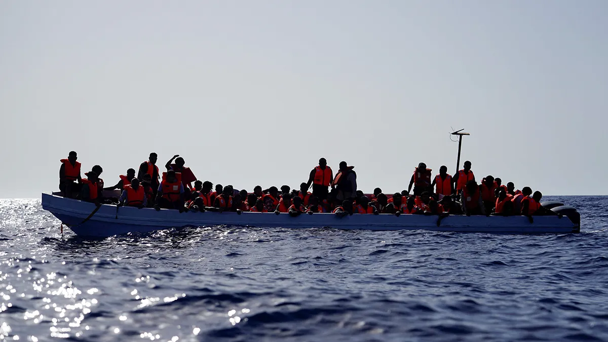 Migrantes en una embarcación de fibra de vidrio esperan ser asistidos por los socorristas del barco de rescate “Astral” de la ONG Open Arms en aguas internacionales - REUTERS/ ANA BELTRAN