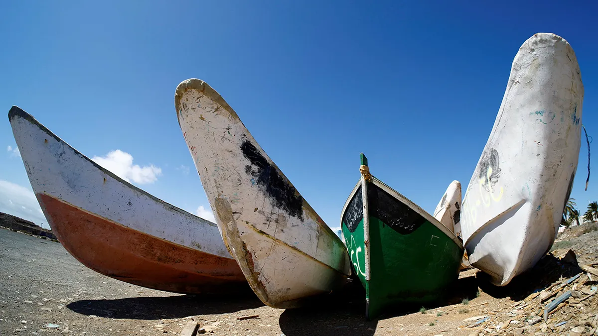 Varias embarcaciones de madera abandonadas utilizadas por migrantes para llegar a las Islas Canarias, en Arinaga, al sureste de la isla de Gran Canaria - REUTERS/ BORJA SUÁREZ