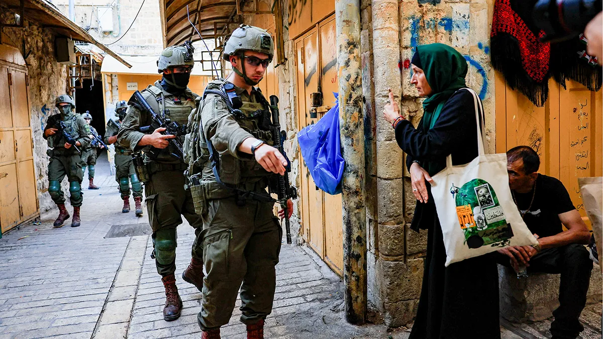 <p>Tropas israelíes caminan durante una visita semanal a colonos en Hebrón, Cisjordania ocupada por Israel, el 23 de agosto de 2025 - REUTERS/ MUSSA QAWASMA</p>
