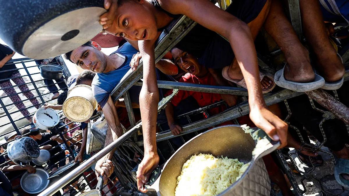 <p>Palestinos esperan recibir comida de un comedor social después de que el sistema de monitoreo global del hambre, Clasificación Integrada de Fases de Seguridad Alimentaria (IPC), anunciara que la ciudad de Gaza y sus alrededores sufren oficialmente una hambruna que probablemente se extenderá - REUTERS/ MAHMOD ISSA</p>
