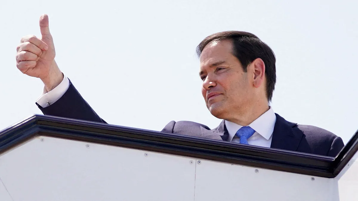 <p>El secretario de Estado de EE. UU., Marco Rubio, hace un gesto a bordo de un avión en el Aeropuerto Internacional de Hamad antes de partir hacia Gran Bretaña después de una visita oficial, en Doha, Qatar, el 16 de septiembre de 2025 - REUTERS/ NATHAN HOWARD</p>
