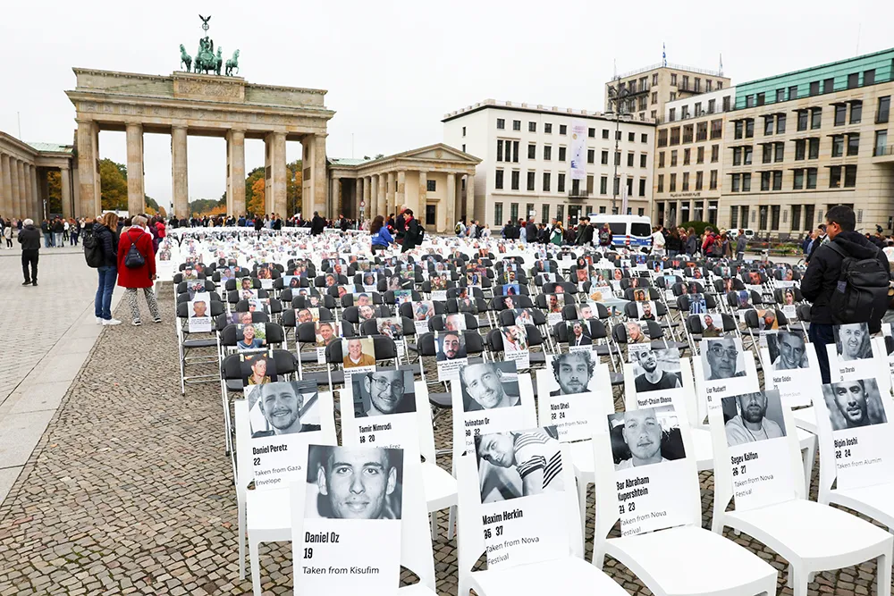 <p>Imágenes de las víctimas se colocan en sillas mientras la gente asiste a una vigilia para conmemorar el segundo aniversario del mortal ataque del 7 de octubre de 2023 contra Israel por parte de Hamás desde Gaza, en la Puerta de Brandeburgo en Berlín, Alemania, el 7 de octubre de 2025 - REUTERS/ LISI NIESNER</p>
