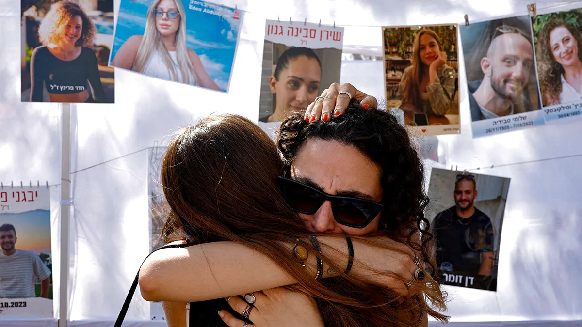 <p>Dos familares de las victimas se abrazan mientras visitan el sitio del festival Nova, donde los asistentes fueron asesinados y secuestrados durante el mortal ataque del 7 de octubre de 2023 contra Israel por parte de Hamás desde Gaza, en el segundo aniversario, en Reim, sur de Israel, el 7 de octubre de 2025 - REUTERS/ AMIR COHEN</p>
