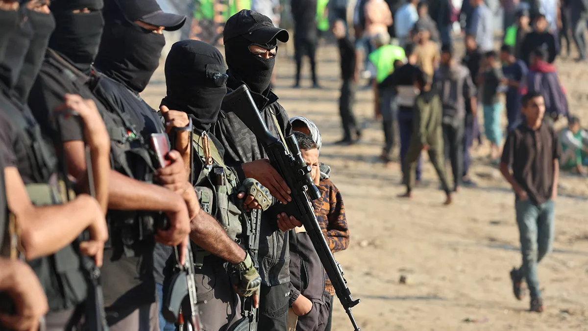 <p>Militantes palestinos hacen guardia el día en que los rehenes retenidos en Gaza desde el mortal ataque del 7 de octubre de 2023 son entregados al Comité Internacional de la Cruz Roja (CICR), como parte de un acuerdo de alto el fuego e intercambio de rehenes por prisioneros entre Hamás e Israel, en Khan Younis, sur de la Franja de Gaza, el 13 de octubre de 2025 - REUTERS/ RAMADAN ABED </p>
