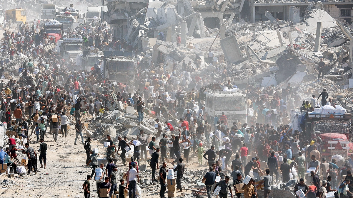 <p>Palestinos recogen ayuda humanitaria de camiones que entraron en Gaza, en Khan Younis, en el sur de la Franja de Gaza, el 12 de octubre de 2025 - REUTERS/ RAMADAN ABED</p>
