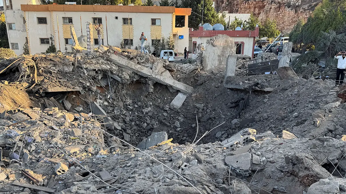 <p>Unos hombres toman fotografías de un cráter en una fábrica de cemento tras los ataques israelíes, según la agencia estatal de noticias libanesa NNA, en Ansar, en el sur del Líbano, el 17 de octubre de 2025 - REUTERS/ ALI HANKIR</p>
